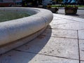 White rustic stone fountain wall and ledge with paving below