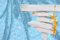 White rustic wood arrow signs with blue yellow starfish over turquoise blue mosaic pool water