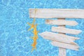 White rustic wood arrow signs with yellow starfish over turquoise blue mosaic pool water