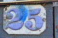 A white house number plaque, showing the number twenty five Royalty Free Stock Photo