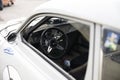 White SAab 96 on a parkinglot with the steeringwheel.