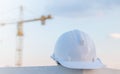 The white safety helmet at construction site with crane background