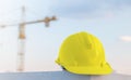 The white safety helmet at construction site with crane background Royalty Free Stock Photo