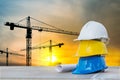 The white safety helmet at construction site with sunset silhouette and crane background Royalty Free Stock Photo