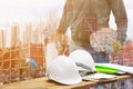 White safety helmet and paper plan blueprint on wood floor table with concept Double Exposure engineering in working building Royalty Free Stock Photo