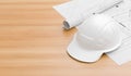 White safety helmet on wooden table with blueprints. Safety helmet for engineers, supervisors, managers and foreman. 3D Royalty Free Stock Photo