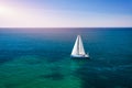 White sail boat isolated in blue sea water. Sailboat in the sea in the sunlight, luxury summer adventure, active vacation in