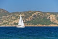 White sailboat along the granite coast of Sardinia