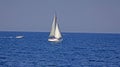 White sailboat in the blue sea. Yacht against the blue sea