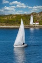 White Sailboat and Lighthouse with Blue water