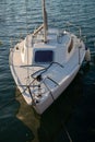 White sailboat moored at the dock of a lake. Royalty Free Stock Photo