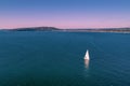 White sailboat near Mornington Peninsula coastline.