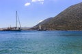 White sailboat in the open sea. Sailing yacht in the open sea with mountains in the background.