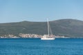 White sailing boat in the blue sea against the background of green mountains. Summer landscape. Copy space Royalty Free Stock Photo