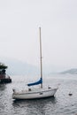 White sailing boat on lake Como. Water sports. The concept of a luxurious lifestyle, mountain background Royalty Free Stock Photo