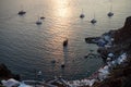 White sailing ships in and out Oia port for beautiful sunset view with sea ocean light reflection background Royalty Free Stock Photo