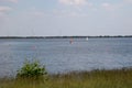 A white sailor and a wind surfer at the storage sea geeste germany with blue sky and white clouds Royalty Free Stock Photo