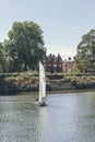 A white sails sailboat maneuvers on the River Thames near Richmond, London