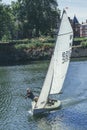 A white sails sailboat maneuvers on the River Thames near Richmond, London