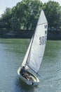 A white sails sailboat maneuvers on the River Thames near Richmond, London