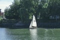 A white sails sailboat maneuvers on the River Thames near Richmond, London Royalty Free Stock Photo