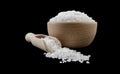 White salt crystals in wooden bowl and scoop isolated on black background. Spices and food ingredients Royalty Free Stock Photo