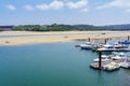 White sand beach with boats anchored in the marina on sunny summer day. Santander