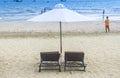 White sand beach with chaise chairs and white umbrella in clear blue sky with many tourists at Muine Bay Resort, Mui Ne, Phan