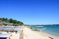 White sand beach with clear blue sky, waters and tourist boats