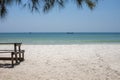 White sand beach with rustic wooden bench and table. Tropical island in South Asia. Turquoise blue sea landscape. Royalty Free Stock Photo