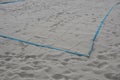 White sand beach volleyball court. white soft dunes fenced with nets. The lines of the playing field are made of blue textile plas Royalty Free Stock Photo