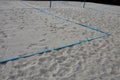 White sand beach volleyball court. white soft dunes fenced with nets. The lines of the playing field are made of blue textile plas Royalty Free Stock Photo