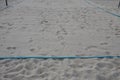 White sand beach volleyball court. white soft dunes fenced with nets. The lines of the playing field are made of blue textile plas Royalty Free Stock Photo