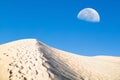 White sand dunes and blue sky with a half moon. Royalty Free Stock Photo