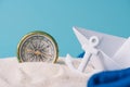 White sand with paper boat, anchor and compass Royalty Free Stock Photo