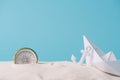 White sand with paper boat, compass and anchor Royalty Free Stock Photo