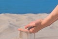 White Sand pours through fingers. Beautiful sandy beach background.