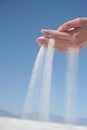 White sand spills around and through female hand. Royalty Free Stock Photo