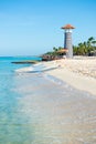 White sand, tropical palm trees and lighthouse on sandy shore Royalty Free Stock Photo