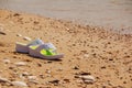 White sandals on the beach. Flipflops on a sandy ocean beach - summer vacation concept. Beach fashion. Female summer Royalty Free Stock Photo