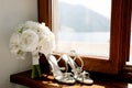 White sandals of the bride on the windowsill with a bouquet of roses on a wooden windowsill by the window overlooking