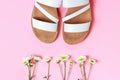 The white sandals and flowers on pink background top view. Royalty Free Stock Photo