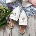 White sandals with flowers on a wooden background Royalty Free Stock Photo