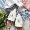 White sandals with flowers on a wooden background Royalty Free Stock Photo
