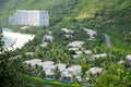 White sandy beach with multistory hotel resort and upscale neighborhood of two story white painted villas, swimming pool, lush Royalty Free Stock Photo