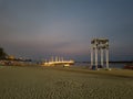 white sandy beachside view in the evening with bridge lights and stage performances Royalty Free Stock Photo