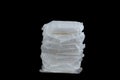 White sanitary individually wrapped napkin pads in stack on black background. Menorrhagia, heavy menstruation bleeding