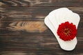 White sanitary pad, hygiene protection on a brown background. Gynecological menstrual cycle. A rose flower lies on a menstrual pad