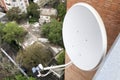 White satellite dish of tv antenna on high house wall for receiving tv signal. Royalty Free Stock Photo