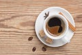 White saucer and cup of coffee decorated spices, cane sugar and coffee beans on rustic wooden table Royalty Free Stock Photo